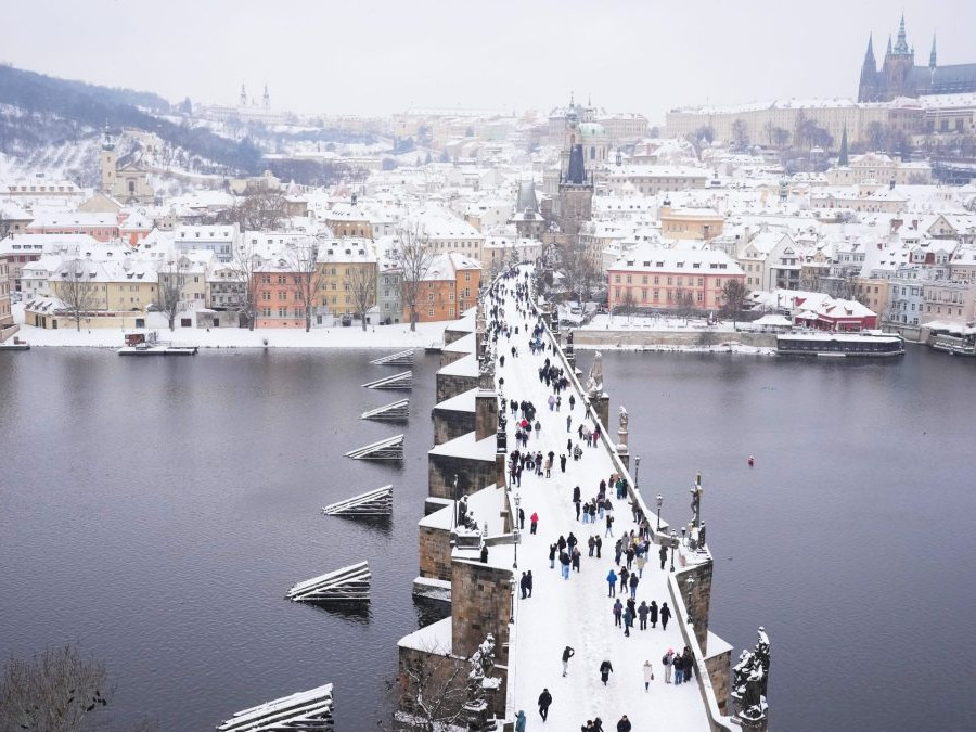 Zasnežený Karlov most v Prahe.