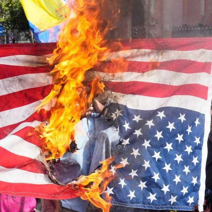 Podporovatelia venezuelskej vlády spálili vlajku Spojených štátov.