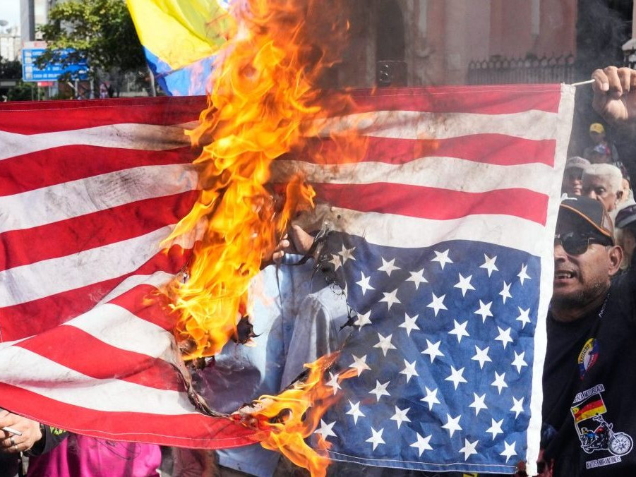 Podporovatelia venezuelskej vlády spálili vlajku Spojených štátov.