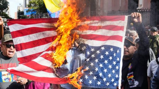 Podporovatelia venezuelskej vlády spálili vlajku Spojených štátov.