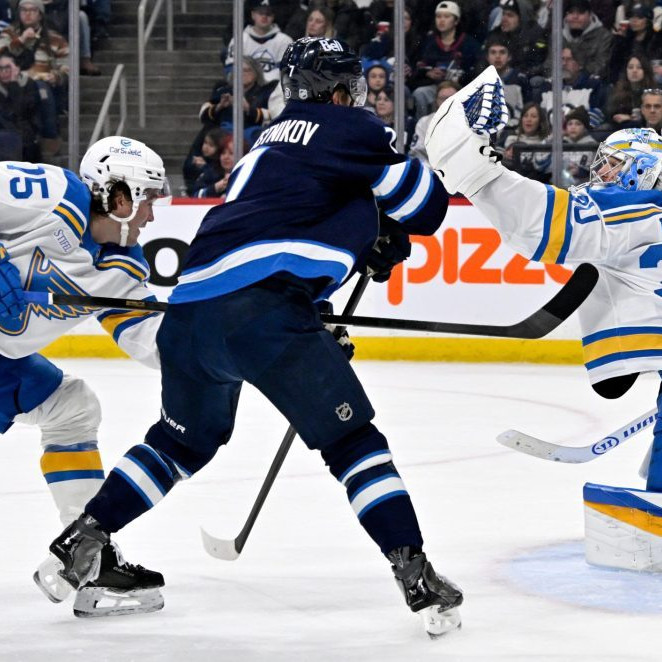 Brankár St. Louis Blues Joel Hofer (30) zasahuje, zatiaľ čo Tyler Tucker (75) bráni proti Vladislavovi Namestnikovovi z Winnipeg Jets.