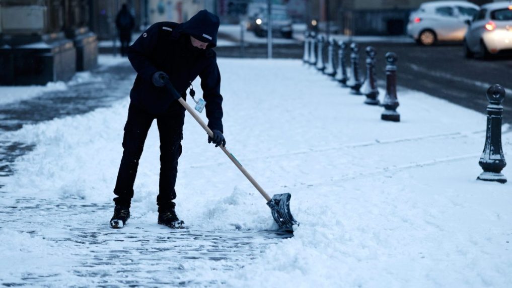 Muž odpratáva sneh v Lille.