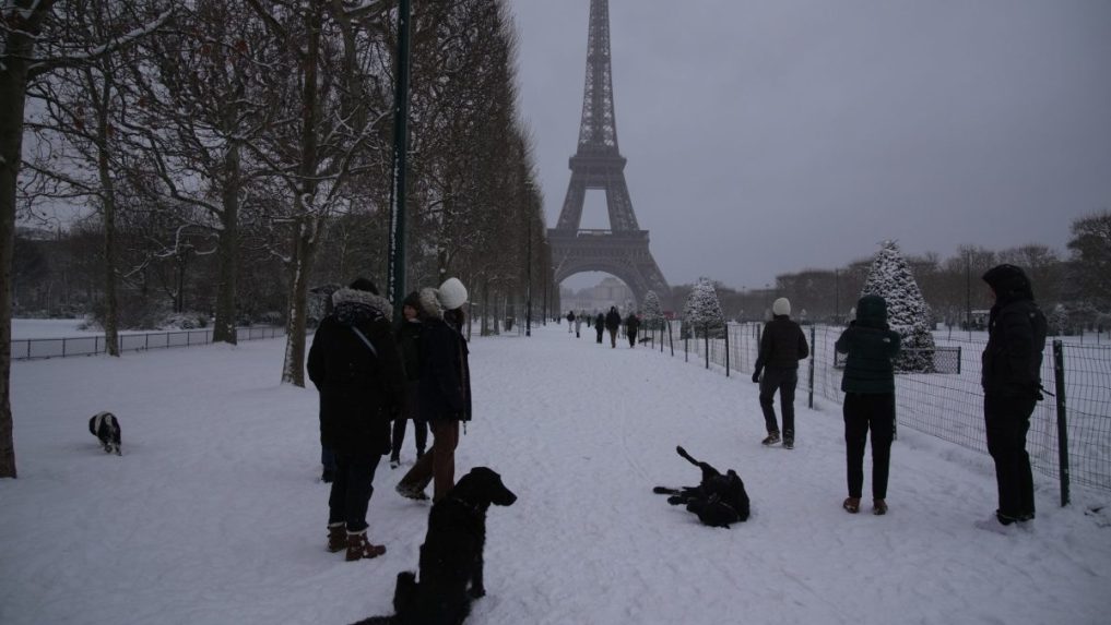 Ľudia venčia svojich psov v zasneženom Paríži.