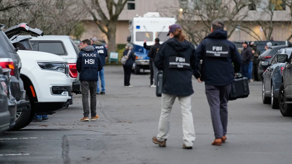 Poškodené auto a približujúci sa pracovníci FBI-