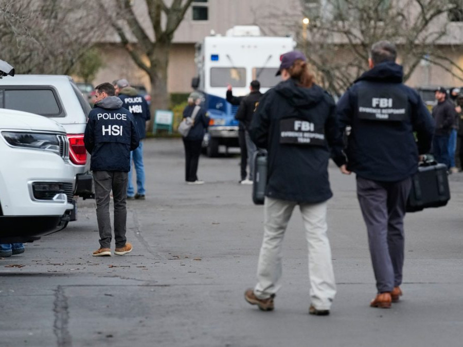 Poškodené auto a približujúci sa pracovníci FBI-