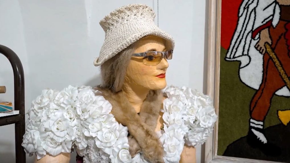 Figur&iacute;na ženy zahalenej do umel&yacute;ch kvetov.