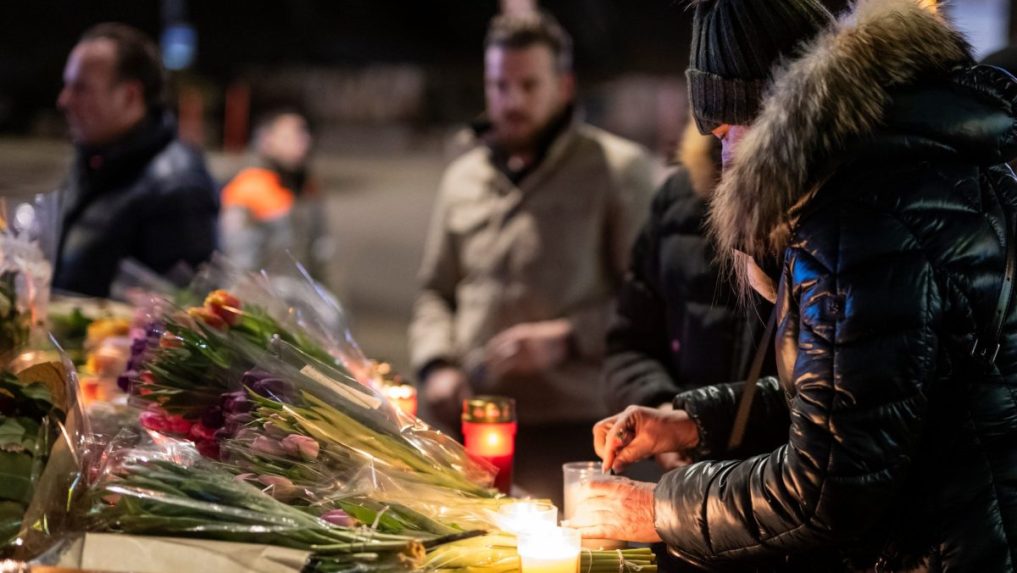 Žena zapaľuje sviečku za obete nočného požiaru v bare vo Švajčiarsku.