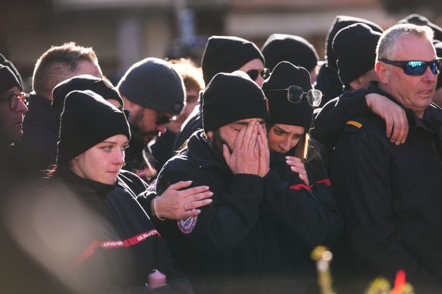 Ľudia smútia za obeťami požiaru.