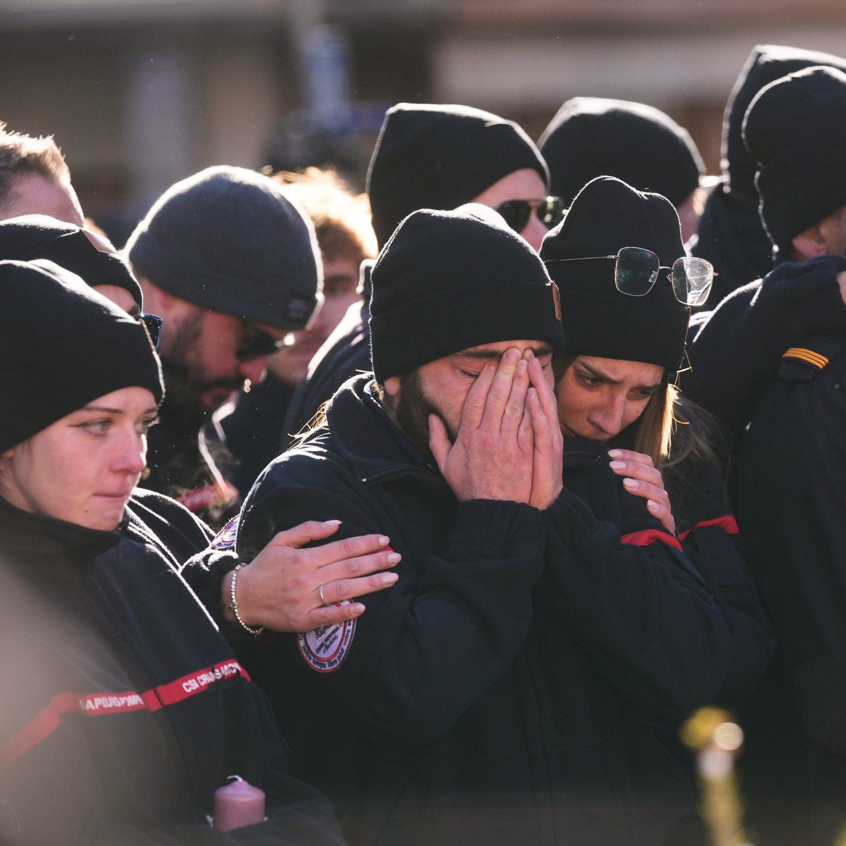 Ľudia smútia za obeťami požiaru.