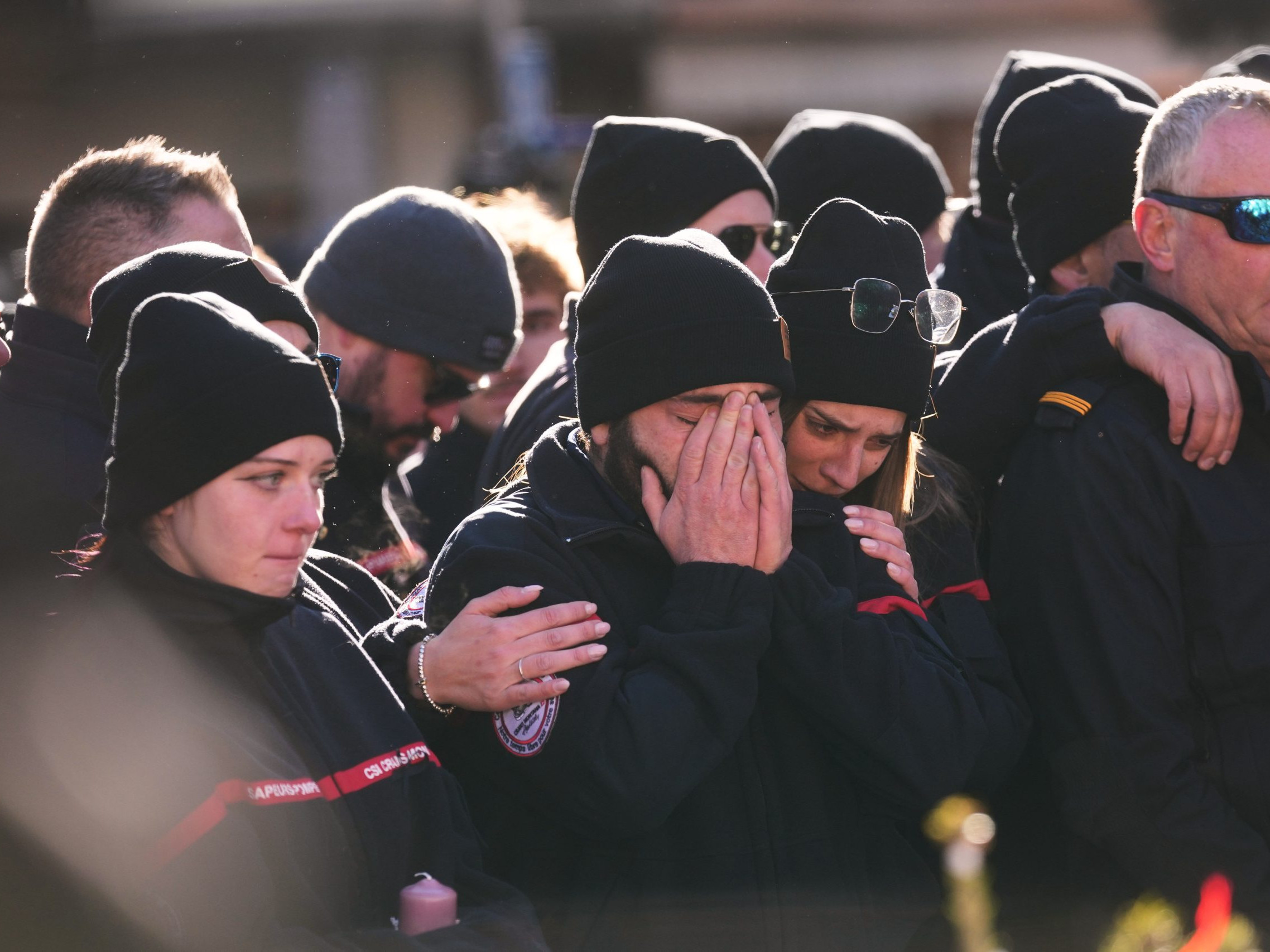 Ľudia smútia za obeťami požiaru.