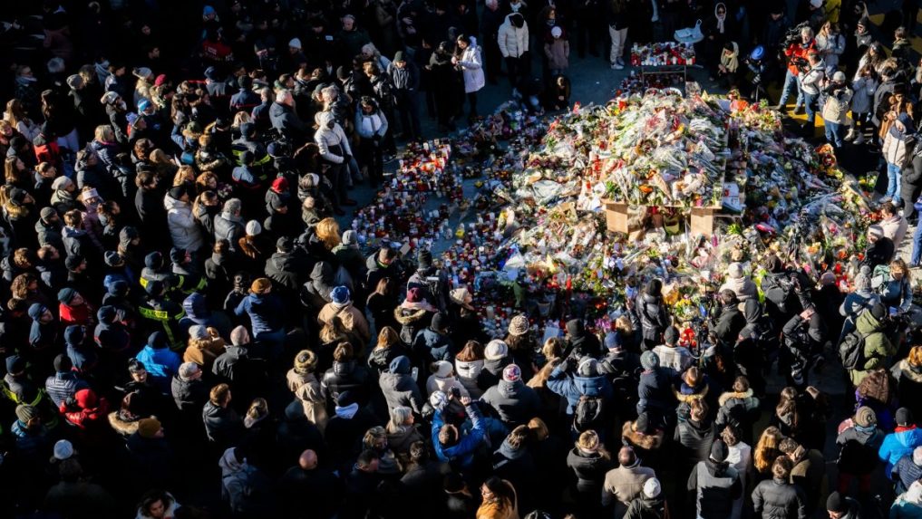 Na snímke ľudia pri pamätníku obetí požiara.