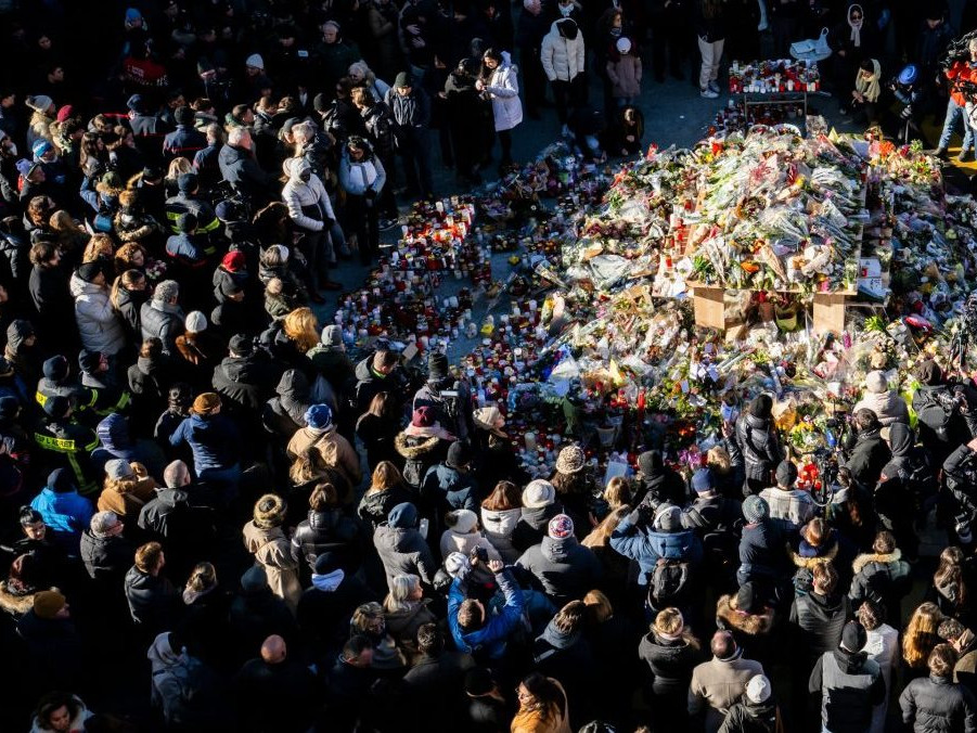 Na snímke ľudia pri pamätníku obetí požiara.