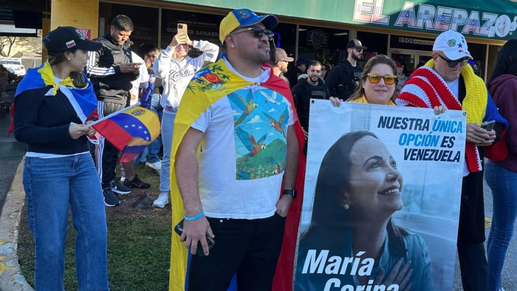 Venezuelčania s transparentom opozičnej líderky a nositeľky Nobelovej ceny za mier.