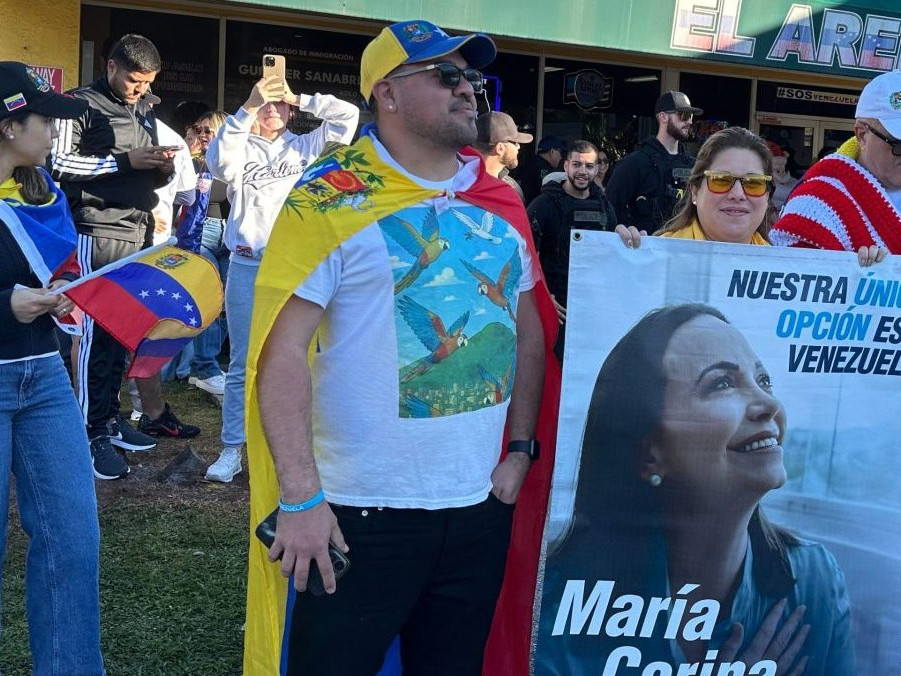 Venezuelčania s transparentom opozičnej líderky a nositeľky Nobelovej ceny za mier.