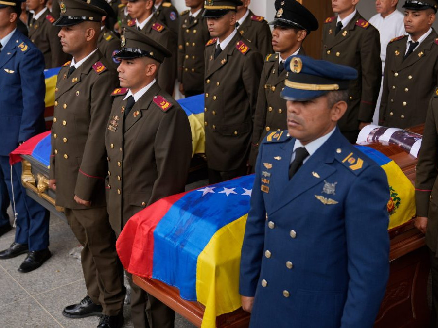Pohreb vojenských príslušníkov vo Venezuele po útoku USA. Na sníme uniformovaní muži stoja s rakvami prikrytými venezuelskou vlajkou.