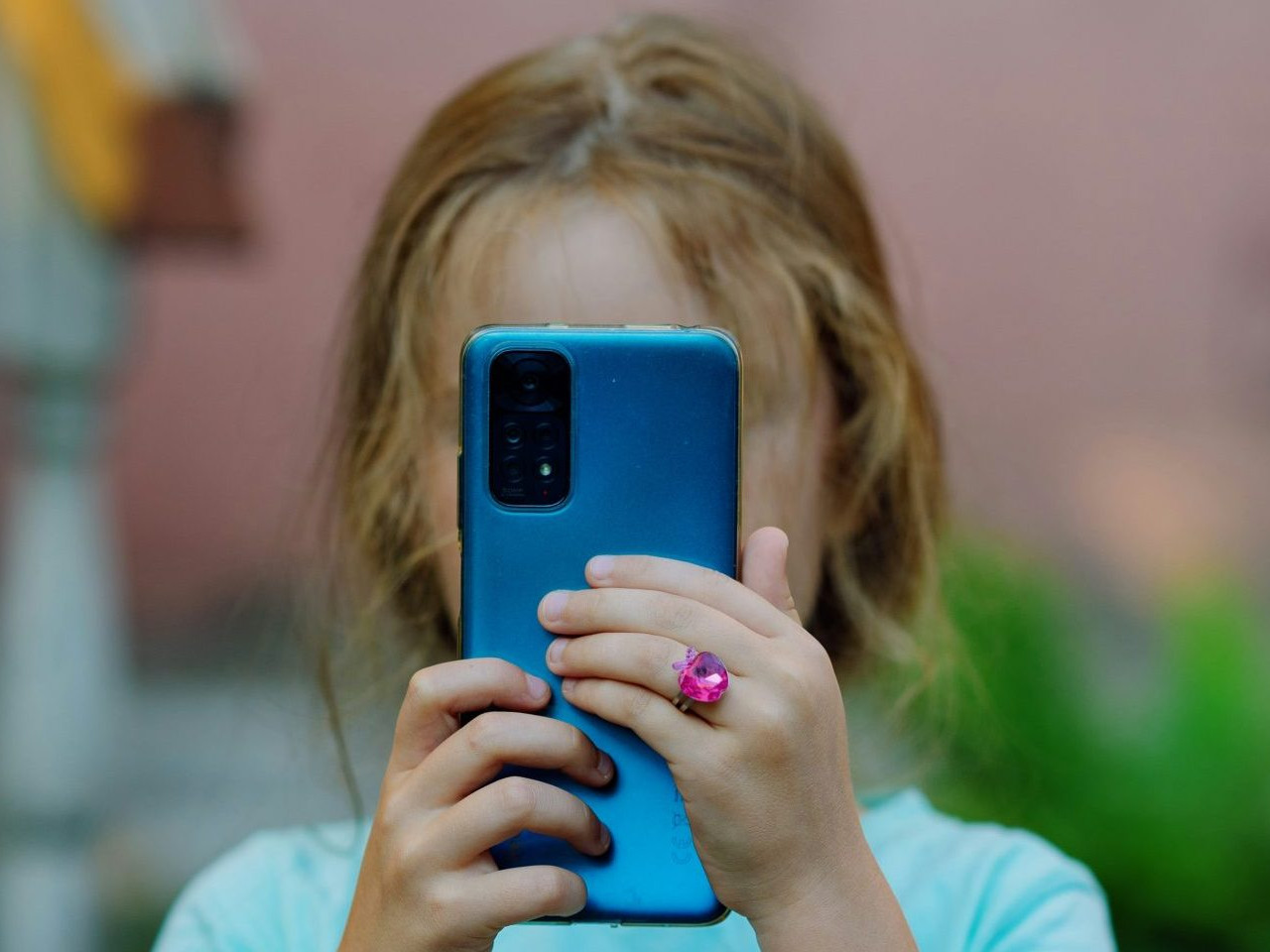 Na snímke dieťa s telefónom.