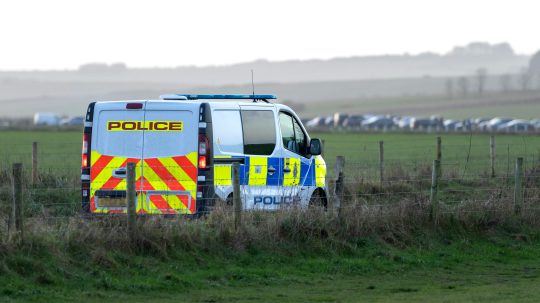 Na snímke je odstavené vozidlo britskej polície, v diaľke kolóna.