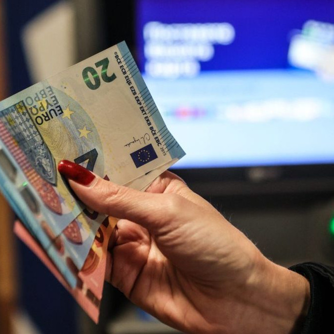 žena drží v ruke eurobankovky