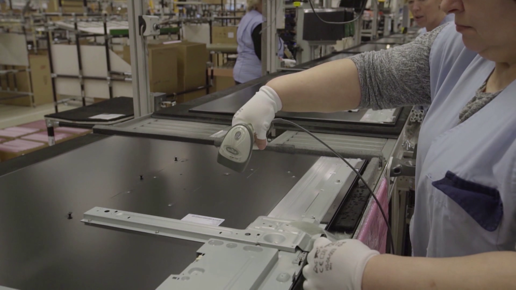 Na snímke je zamestnankyňa za výrobným pásom v elektrovýrobe.