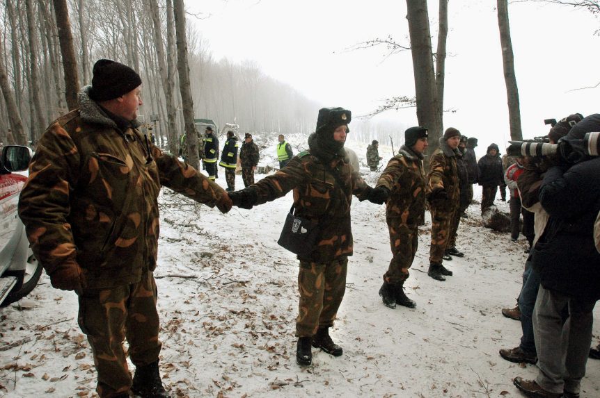 Trosky havarovaného vojenského lietadla AN-24 pri obci Hejce a vojaci.