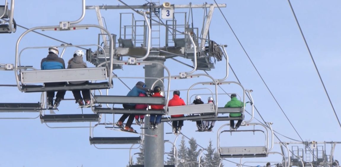 Lanovka nad zasneženým svahom.