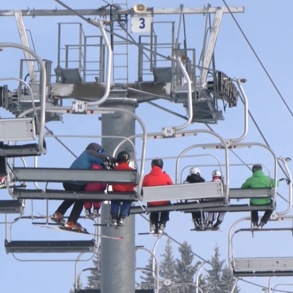 Lanovka nad zasneženým svahom.