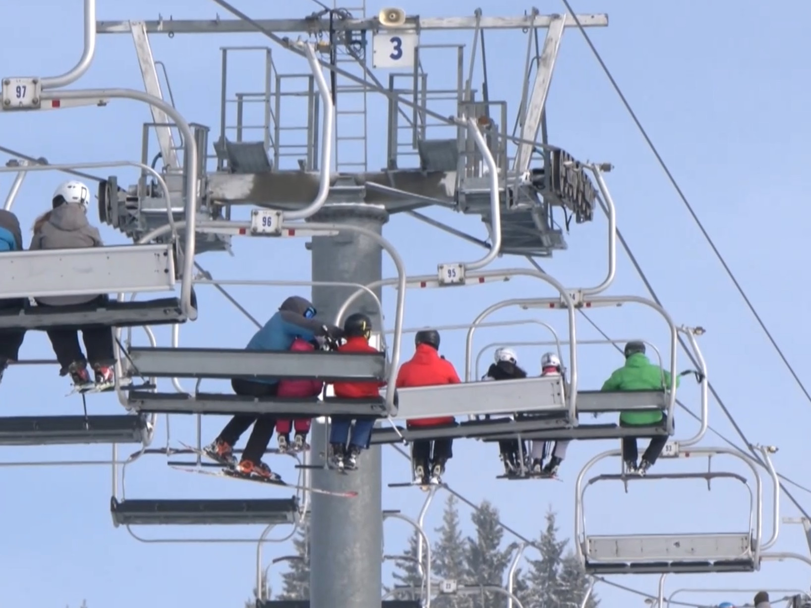 Lanovka nad zasneženým svahom.