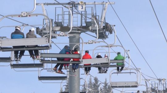 Lanovka nad zasneženým svahom.