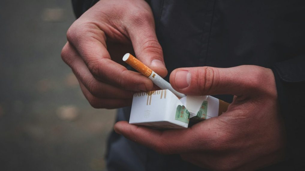 na snímke krabička cigariet v rukách človeka