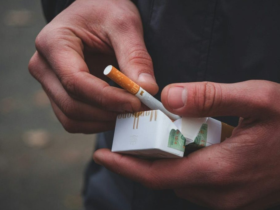 na snímke krabička cigariet v rukách človeka