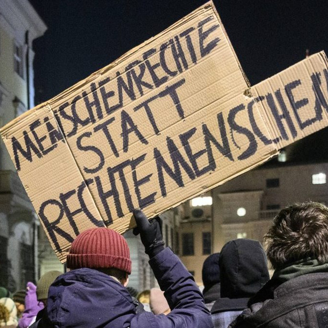 Muž s transparentom, na ktorom sa píše "Ľudské práva namiesto pravicových ľudí".