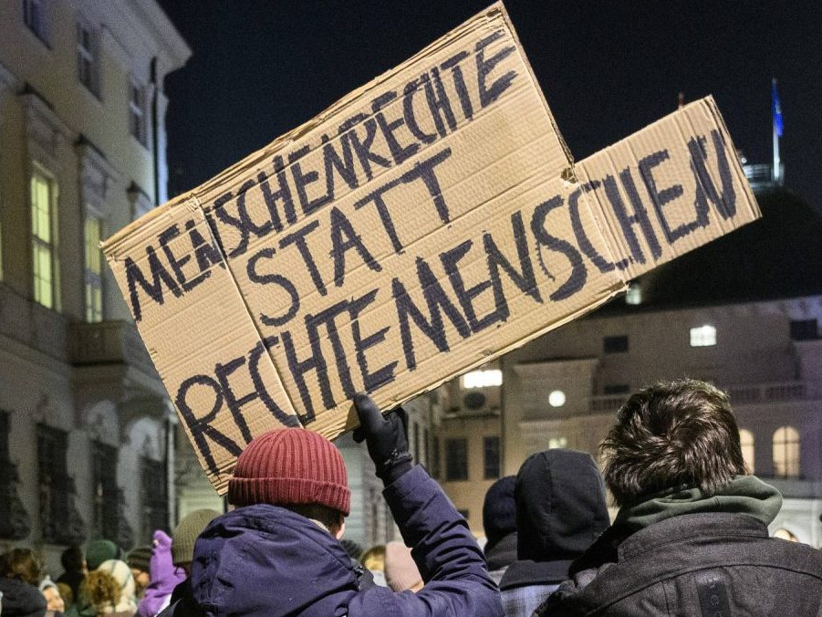 Muž s transparentom, na ktorom sa píše "Ľudské práva namiesto pravicových ľudí".