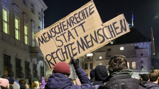 Muž s transparentom, na ktorom sa píše "Ľudské práva namiesto pravicových ľudí".