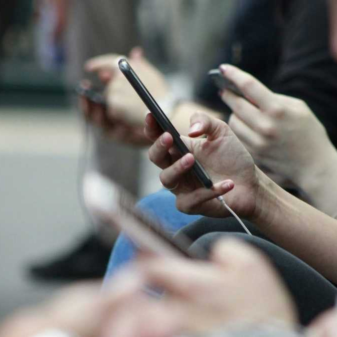 Ilustračná snímka ľudí s mobilnými telefónmi.