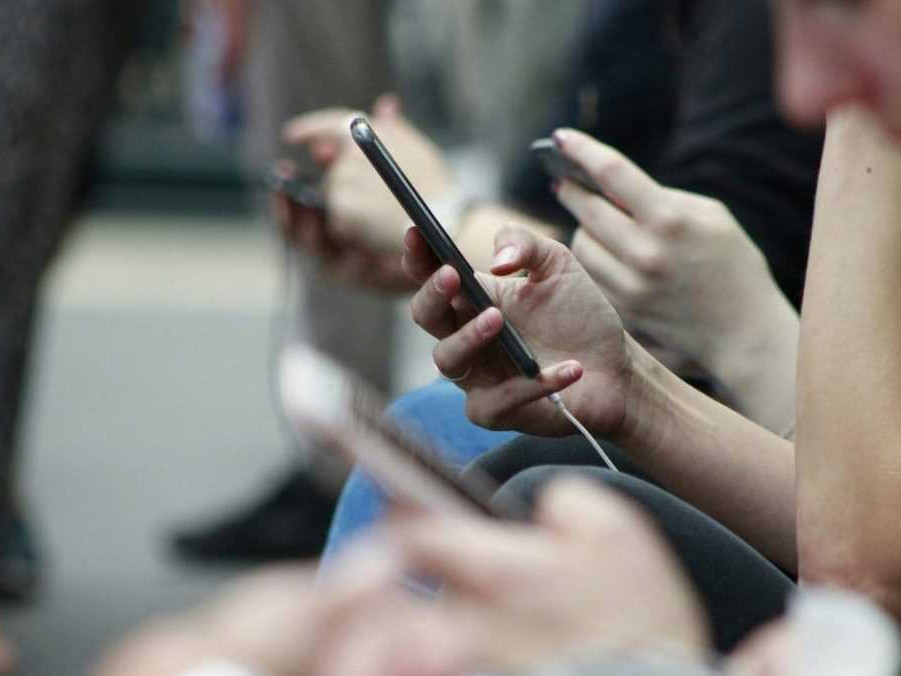 Ilustračná snímka ľudí s mobilnými telefónmi.