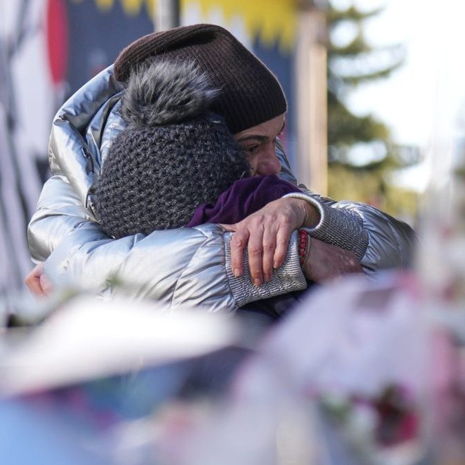 Na snímke ľudia smútia neďaleko uzavretého baru, v ktorom sa odohrala tragédia.