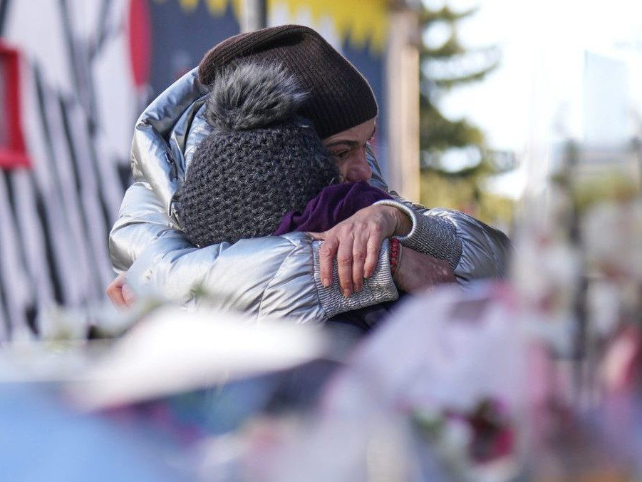 Na snímke ľudia smútia neďaleko uzavretého baru, v ktorom sa odohrala tragédia.