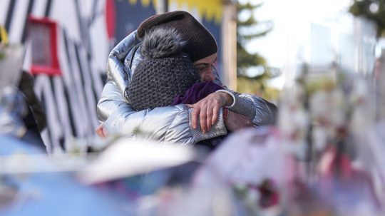 Na snímke ľudia smútia neďaleko uzavretého baru, v ktorom sa odohrala tragédia.