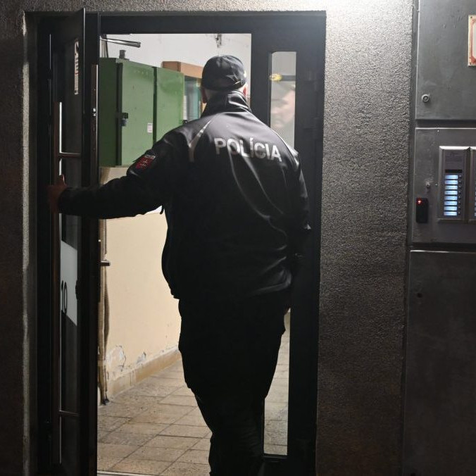 Policajt vchádza do bytového domu vo Vranove nad Topľou.