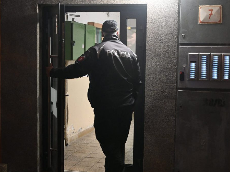 Policajt vchádza do bytového domu vo Vranove nad Topľou.