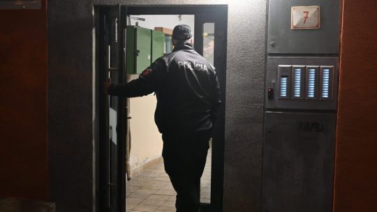 Policajt vchádza do bytového domu vo Vranove nad Topľou.