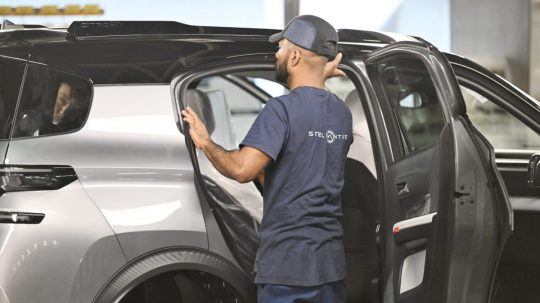 Na ilustračnej snímke zamestnanec v automobilke.