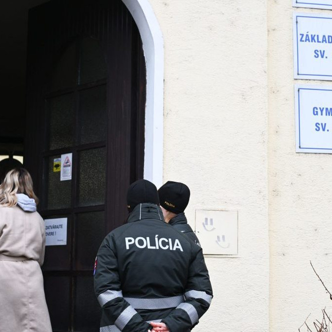 Policajti stoja po streľbe pred Spojenou školou sv. Jozefana v Novom Meste nad Váhom.