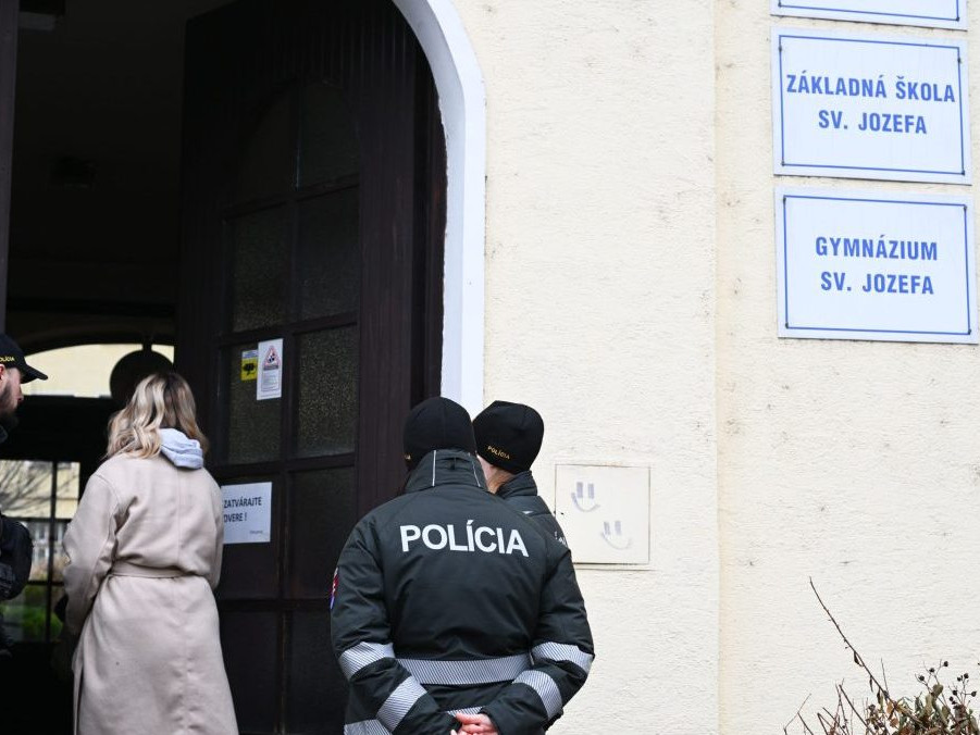 Policajti stoja po streľbe pred Spojenou školou sv. Jozefana v Novom Meste nad Váhom.