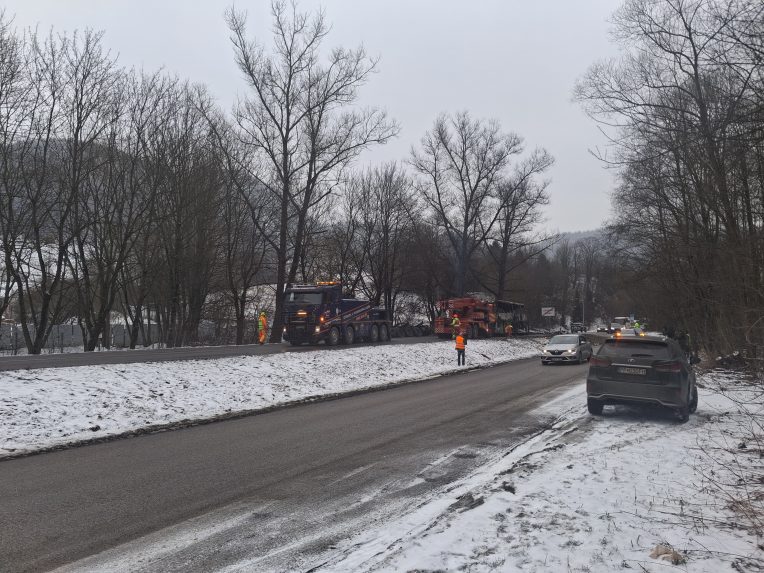 Na snímke v pozadí zhorený autobus po nehode.
