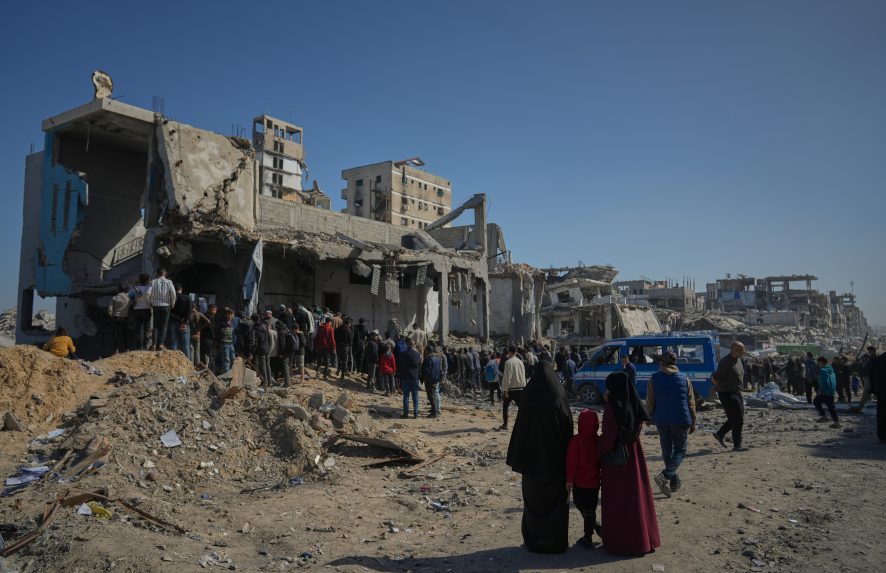 Palestínčania pátrajú po telách v troskách budovy po izraelskom útoku.