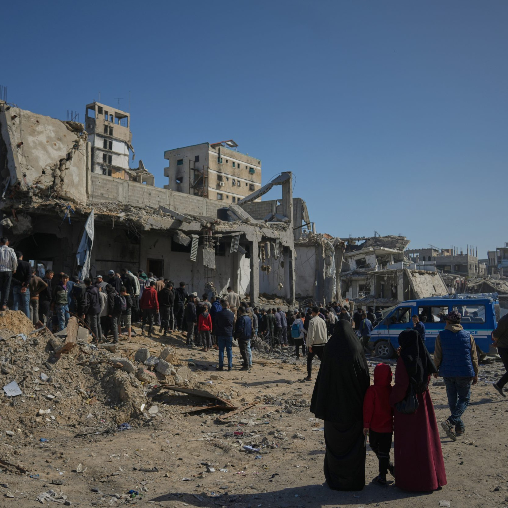 Palestínčania pátrajú po telách v troskách budovy po izraelskom útoku.