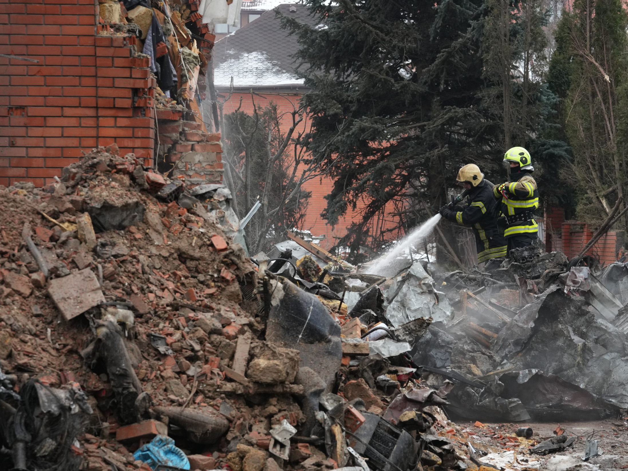 Hasiči hasia trosky po ruskom útoku v Kyjeve.