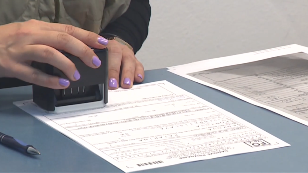 Žena pečiatkuje daňové priznanie.
