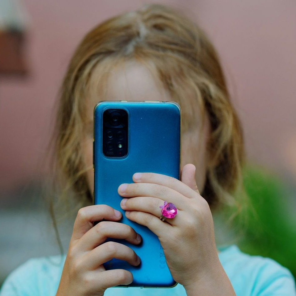 Na snímke dieťa s telefónom.